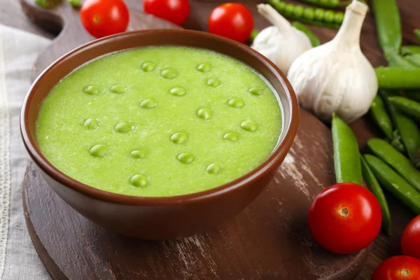 Tasty peas soup and vegetables on table close up — Stock Photo, Image