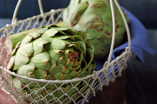 Carciofi in cesto su colore — Foto Stock