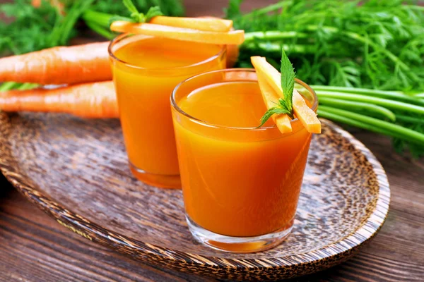 Szklanki soku z marchwi z warzywami na stole z bliska — Zdjęcie stockowe