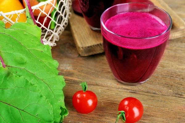 Copo de suco de beterraba com legumes na mesa de perto — Fotografia de Stock