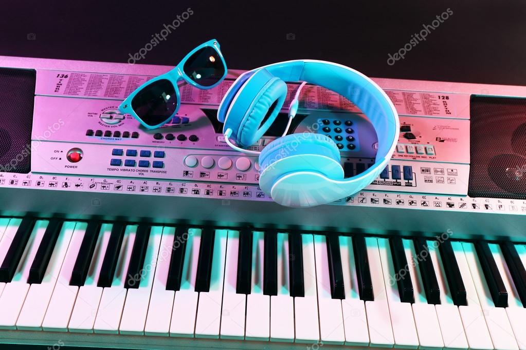 Headphones with sunglasses on synthesizer close up