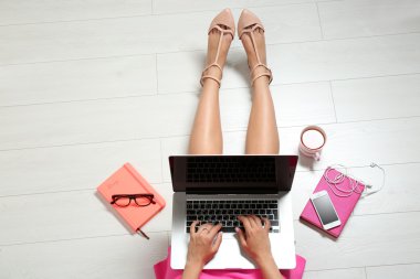 dizüstü bilgisayar ile katta oturan kadın