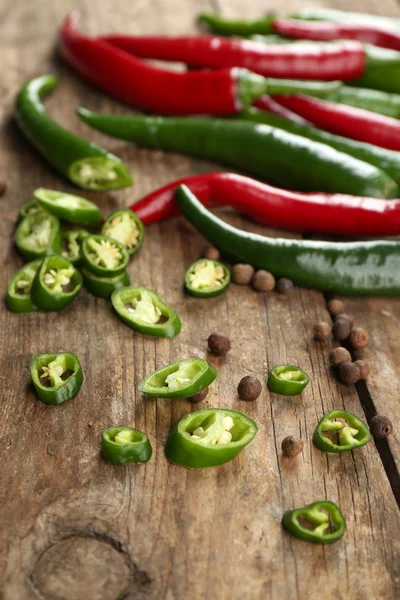 Hot peppers on wooden table close up — Stock Photo, Image