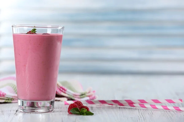 Glas Himbeermilchshake mit Beeren auf Holzgrund — Stockfoto