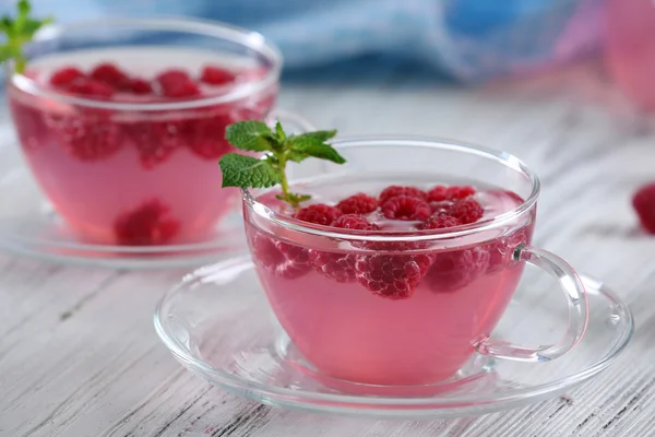 Cups and teapot of raspberry drink — Stock Photo, Image