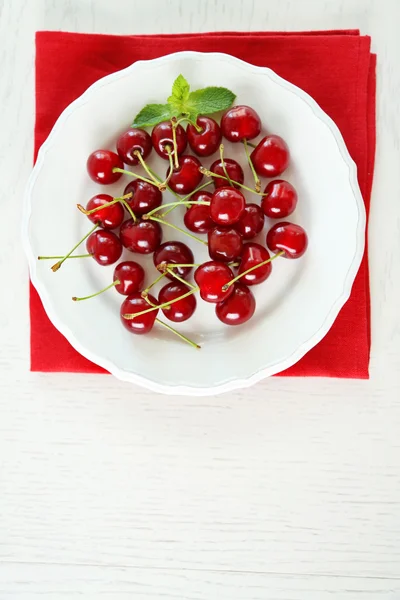 Sweet cherries on plate, on light background — Stock Photo, Image