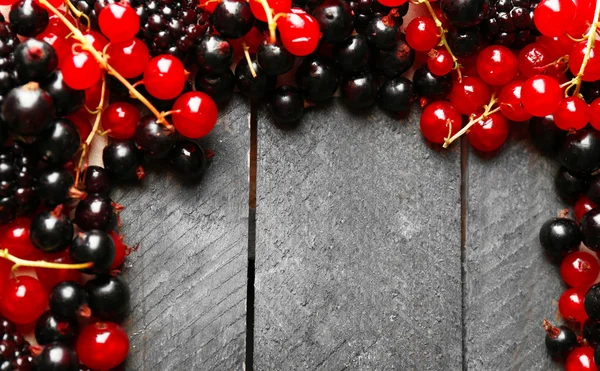 Спелые красные и черные смородины на деревянном фоне — стоковое фото