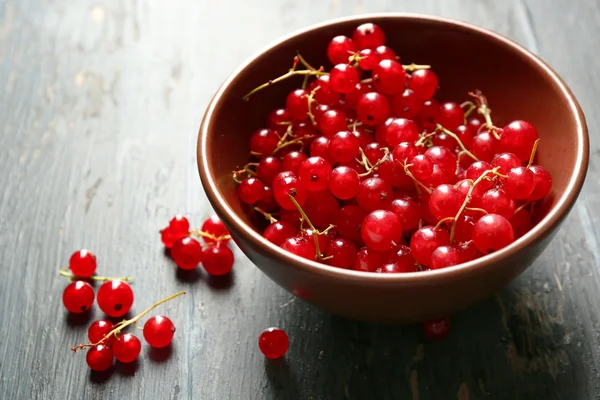 Groseille rouge mûre dans un bol sur fond en bois — Photo