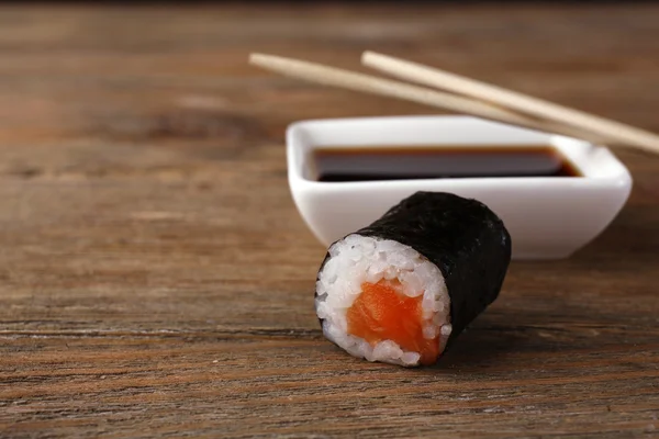 Rollo con salsa y palos en la mesa de madera de cerca — Foto de Stock