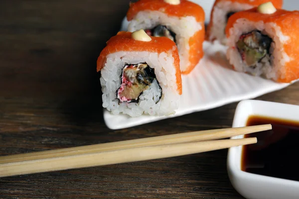 Rollen met saus en stokken op houten tafel close-up — Stockfoto