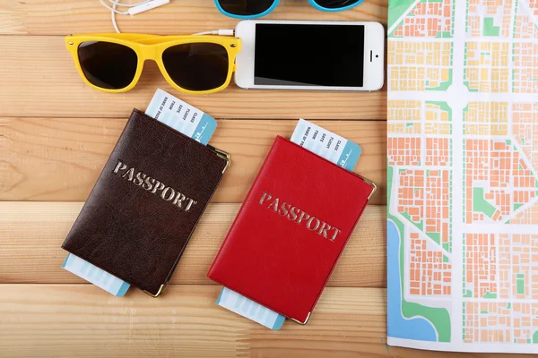 Óculos de sol, passaportes e mapa, de perto, sobre fundo de madeira. Preparação para o conceito de viagem — Fotografia de Stock