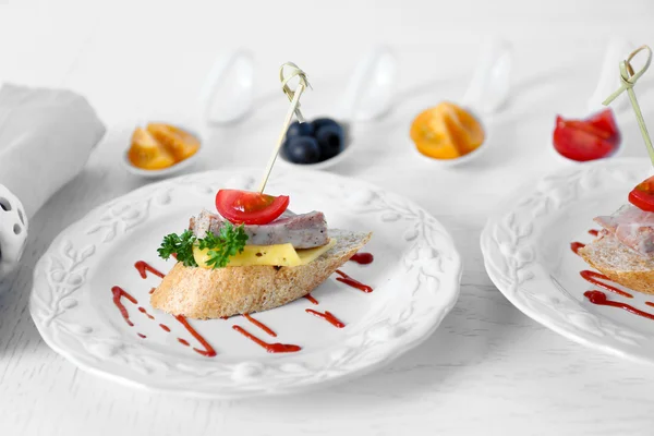 Smakelijke canapeetjes op houten tafel — Stockfoto