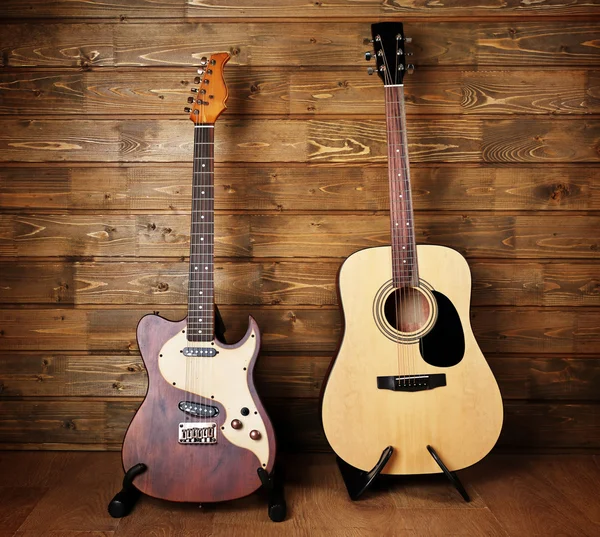 Elektrische en akoestische gitaren op houten achtergrond — Stockfoto