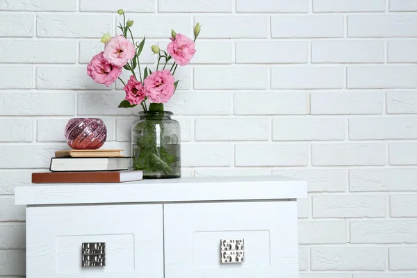 Schöne Blumen mit Büchern auf Backsteinmauer Hintergrund — Stockfoto