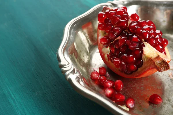 Juicy pomegranate in metal tray on wooden table, closeup — Stock Photo, Image