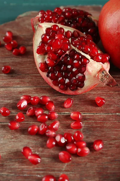 Juicy pomegranate on wooden table, closeup — Stock Photo, Image