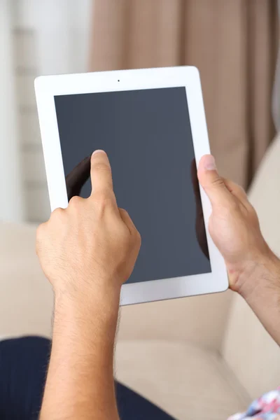 Männliche Hand hält PC-Tablet auf Home-Innenhintergrund — Stockfoto
