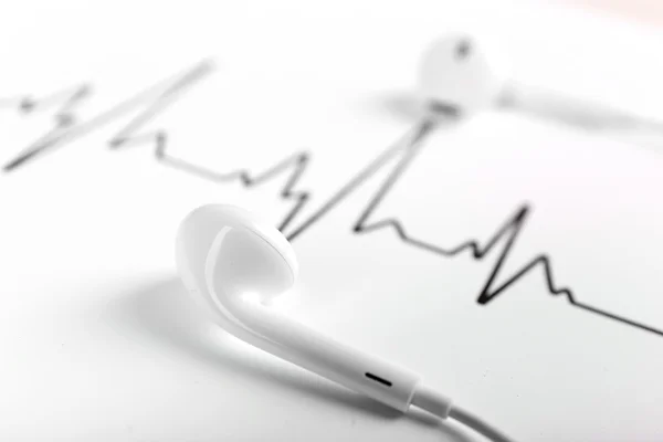 Kopfhörer auf Kardiogramm-Hintergrund — Stockfoto