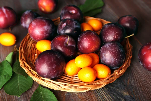 Prunes mûres sur table en bois, gros plan — Photo