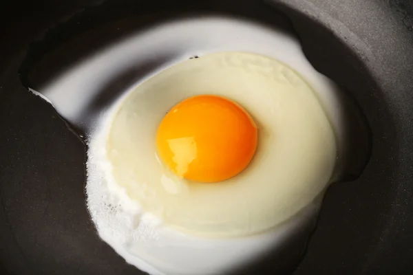 Míchaná vejce na pozadí černé pan — Stock fotografie