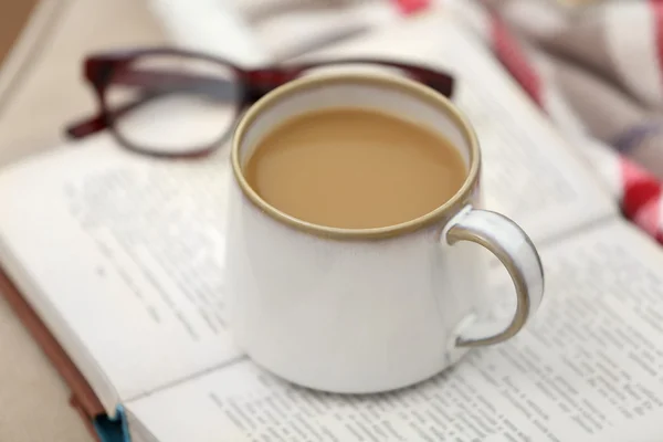 Kopp kaffe med boken på soffan i vardagsrummet — Stockfoto