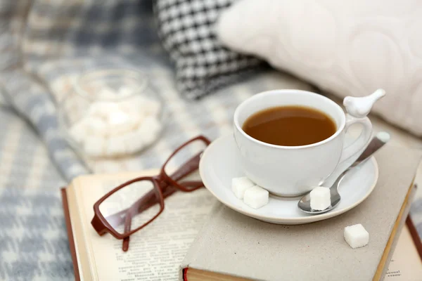 Tazza di caffè con libri sul divano in salotto — Foto Stock