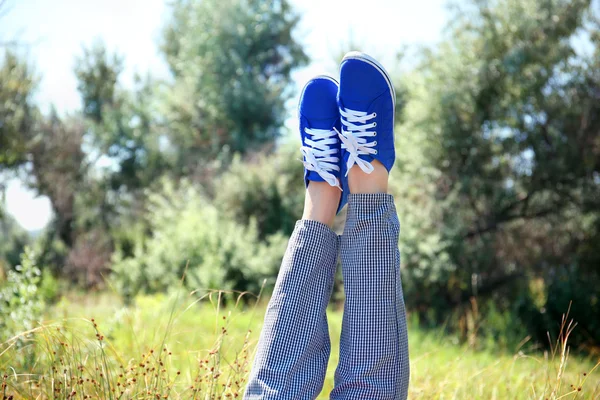 Frauenbeine in bunten Turnschuhen — Stockfoto