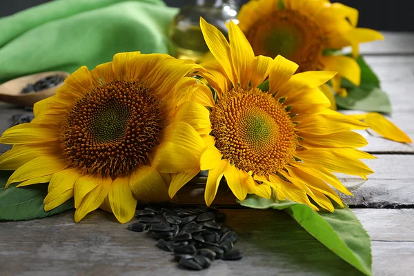 Schöne helle Sonnenblumen mit Samen auf Holztisch aus nächster Nähe — Stockfoto
