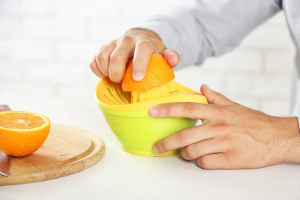 Homem usando espremedor de frutas cítricas — Fotografia de Stock