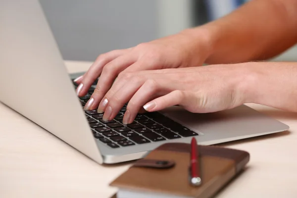 Mulher usando laptop no local de trabalho de perto — Fotografia de Stock