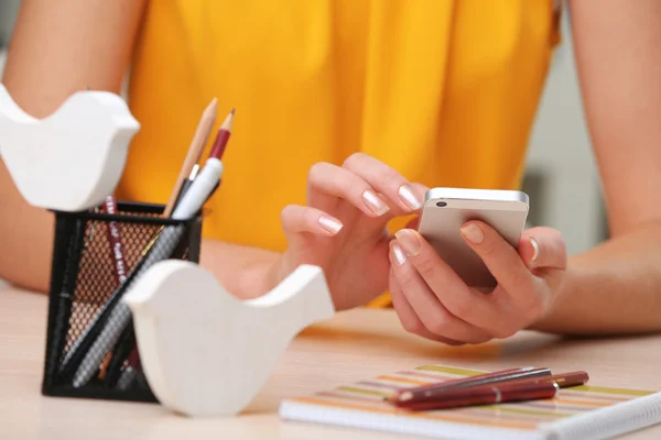 Mulher usando telefone celular no local de trabalho de perto — Fotografia de Stock