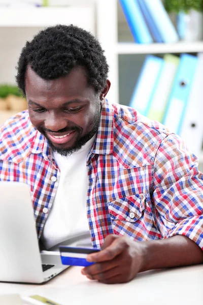 Hombre con laptop y tarjeta de crédito —  Fotos de Stock