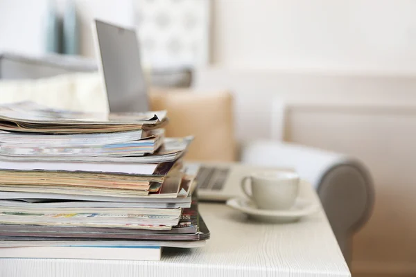 Tidskrifter och laptop på bord — Stockfoto