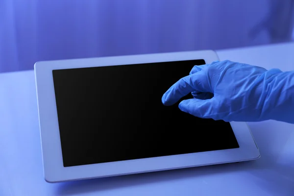 Médico mano en guante de goma usando tableta en la oficina —  Fotos de Stock