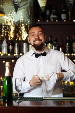 Barmen gözlük iş yerinde siliyor.