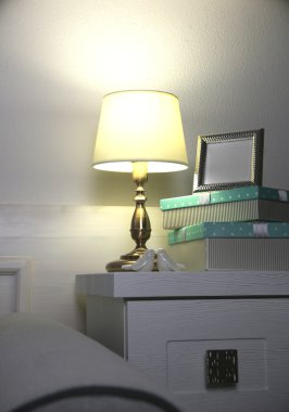 Komidinin üstünde duvar arka plan üzerinde eski moda masa lambası