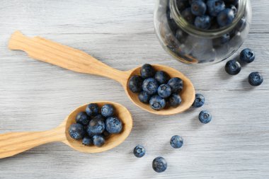 Kaşık ve kavanoz ahşap masa üzerinde taze yaban mersini yakın çekim