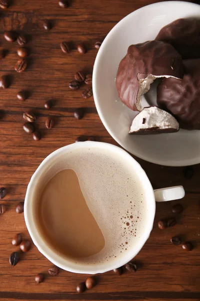 Kopp kaffe med choklad zephyr och spannmål på träbord, ovanifrån — Stockfoto