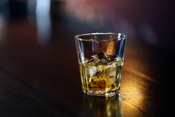 Стакан виски стоит на барной стойке — стоковое фото