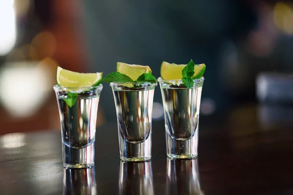 Bicchierini con tequila sul bancone del bar — Foto Stock