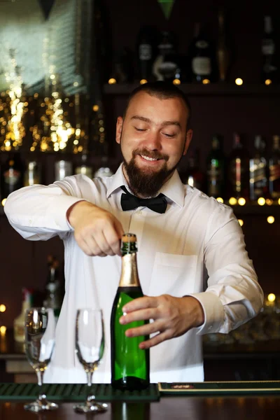 Porträt eines gutaussehenden Barkeepers mit Champagnerflasche — Stockfoto