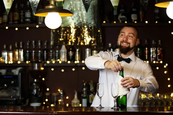 Portrét hezký barman s láhev šampaňského — Stock fotografie