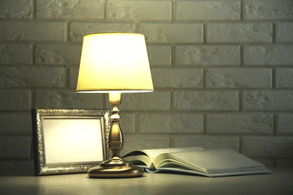 Antigua lámpara de mesa de moda en la mesa sobre fondo de pared de ladrillo —  Fotos de Stock