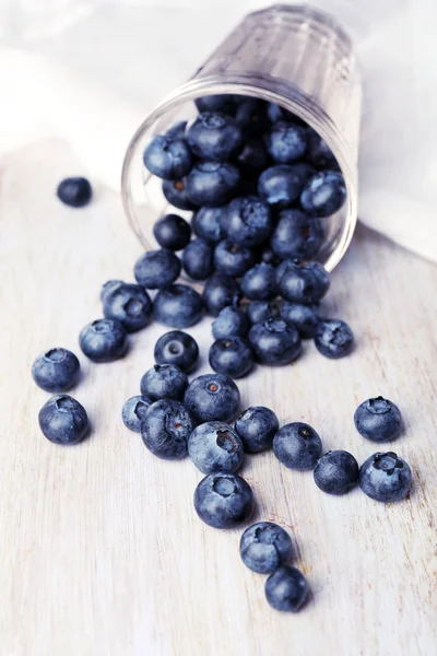 Färska blåbär i glas på träbord nära håll — Stockfoto