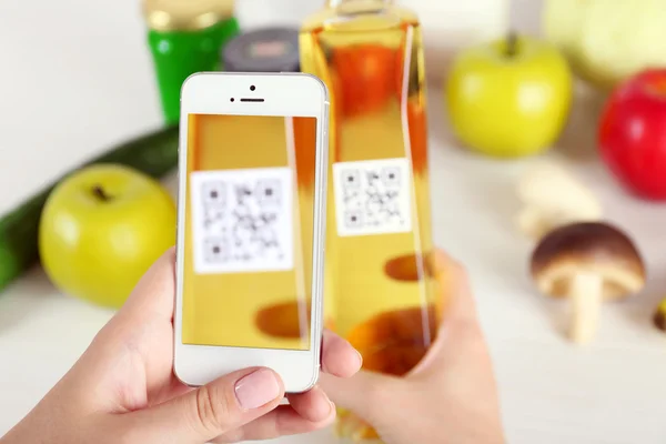 Woman scanning voucher code with mobile phone close up — Stock Photo, Image