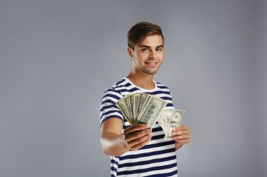 Para gri arka plan üzerinde tutarak yakışıklı genç