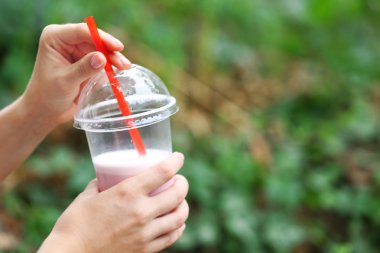 Plastik bardak muzlu süt yakın çekim, açık havada tutan kadın