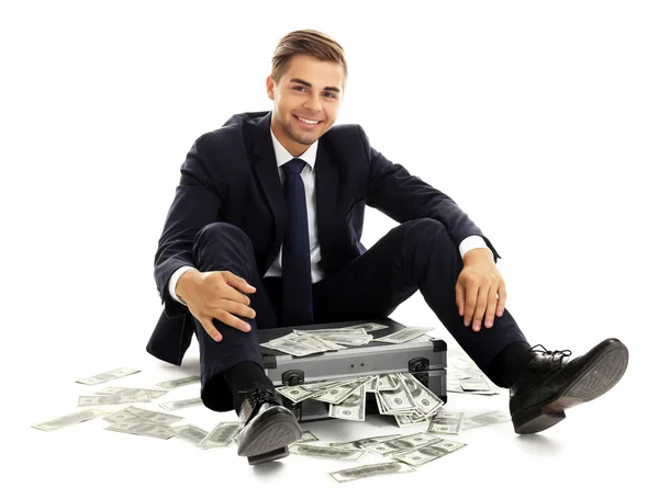 Elegant man sitting on case with money isolated on white — Stock Photo, Image