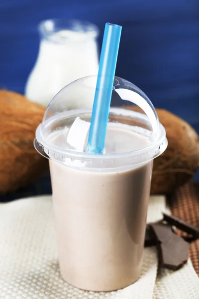 Plastic cup of milkshake on color wooden background — Stock Photo, Image