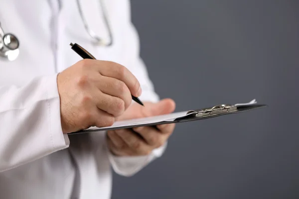 Médico escrevendo na área de transferência — Fotografia de Stock